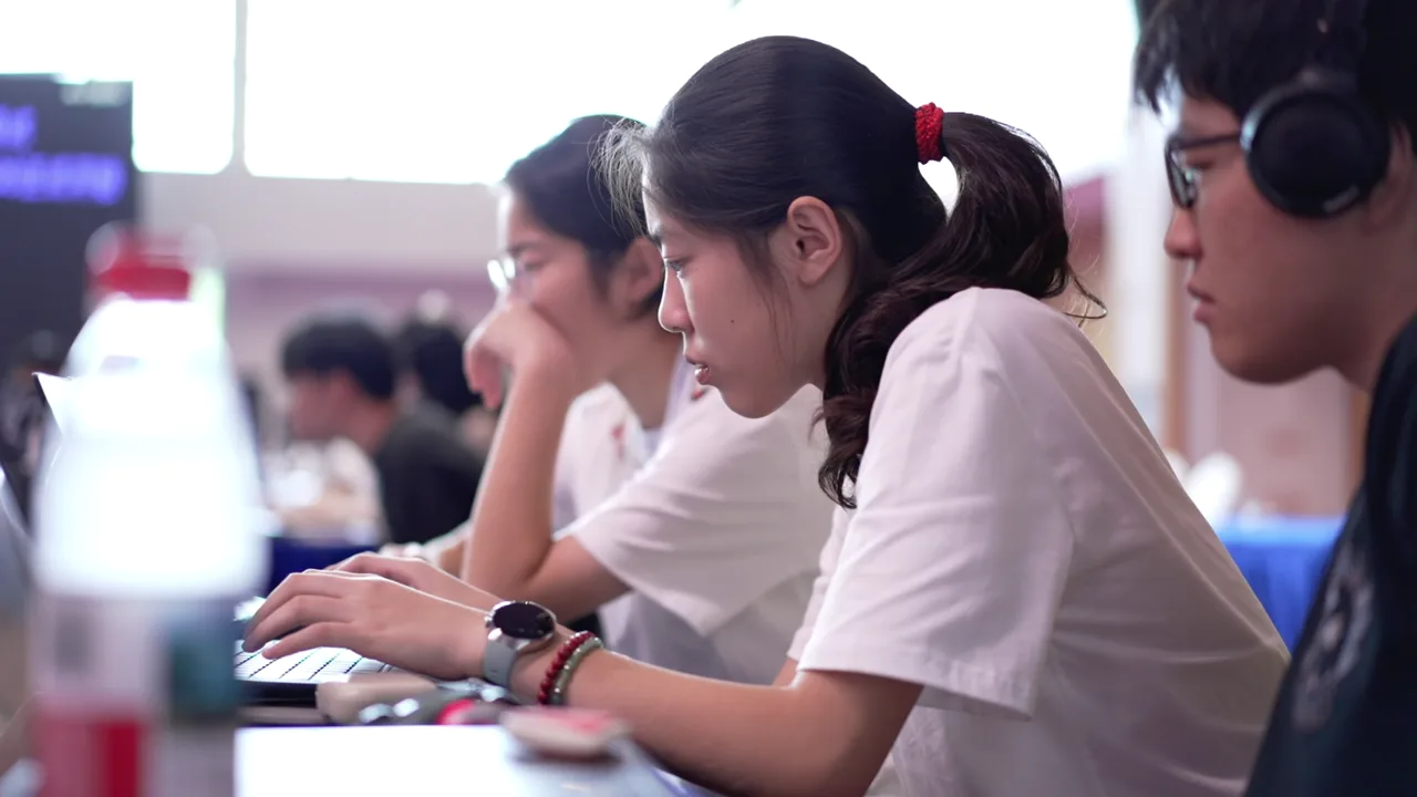 学生围绕电脑协作、讨论与完善方案。